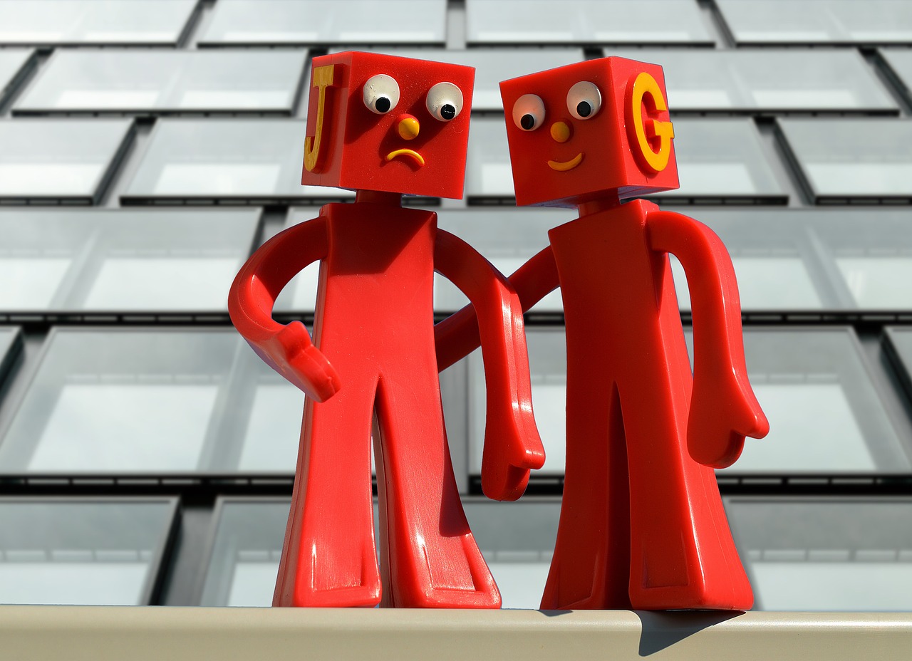 zwei rote Figuren mit frohem und traurigem Gesichtsausdruck