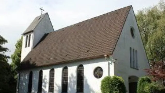 Weiße Kirche mit braunem Dach. 