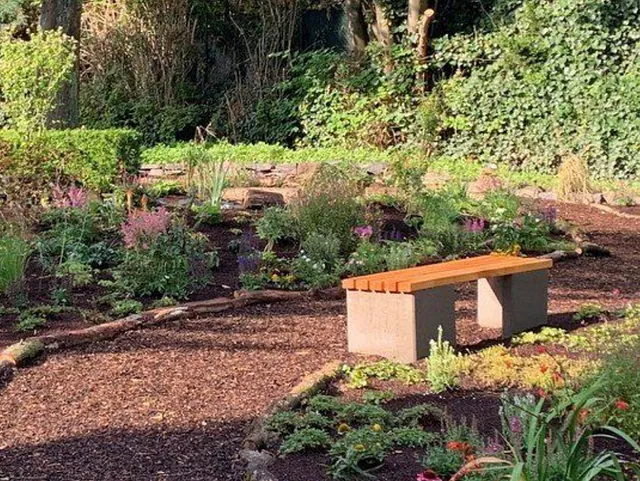  Bepflanzter Garten mit Bank. 