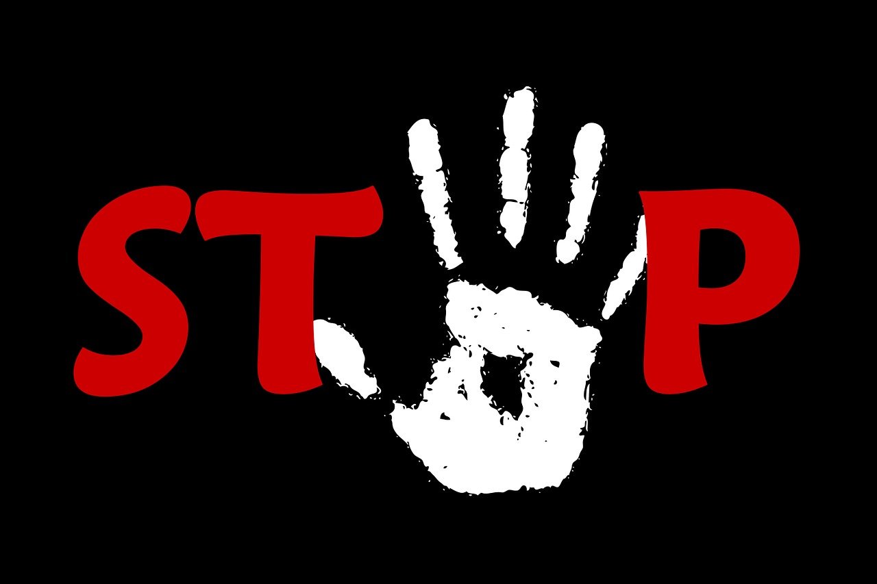 Roter „STOP“-Schriftzug mit einem weißen Handabdruck.