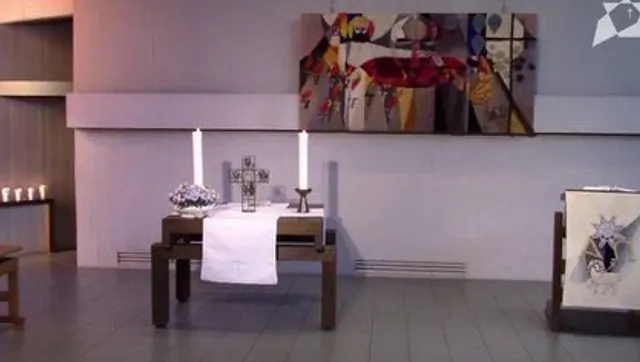 Kircheninterieur mit Altar und Kerzen.