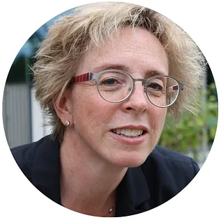 Frau mit blonden, kurzen Haaren und Brille